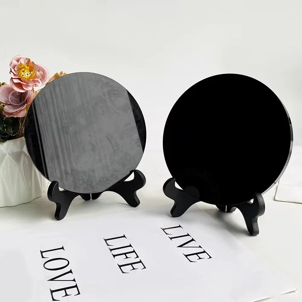 A black obsidian scrying mirror decor with a round, reflective surface is displayed on a white background.
