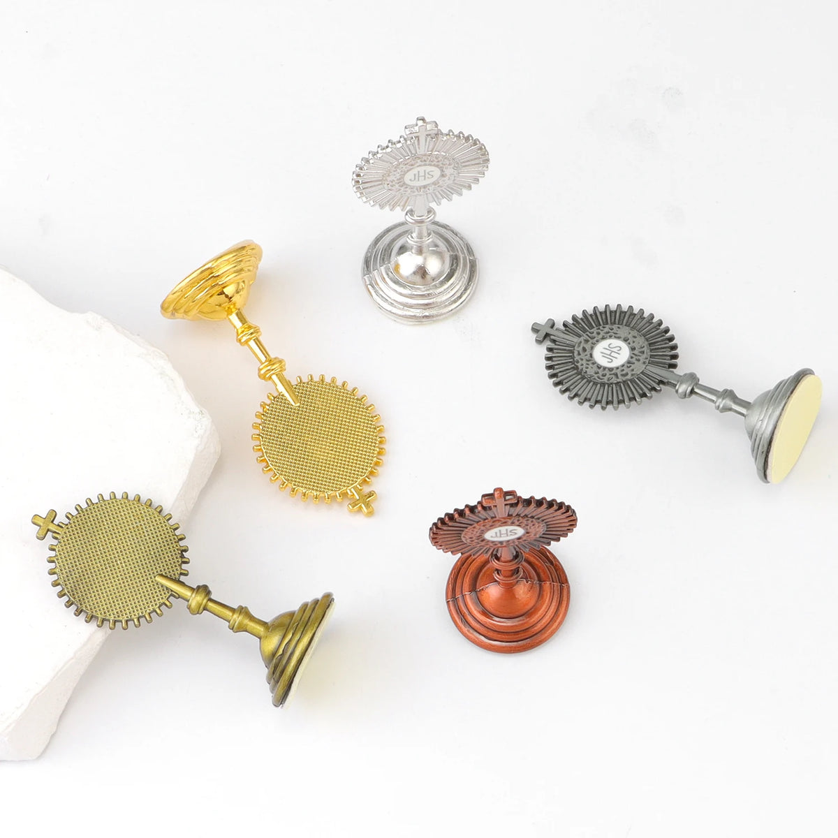 A collection of small metal religious ornaments including a silver bell, gold and silver miniature bells, and an antique copp