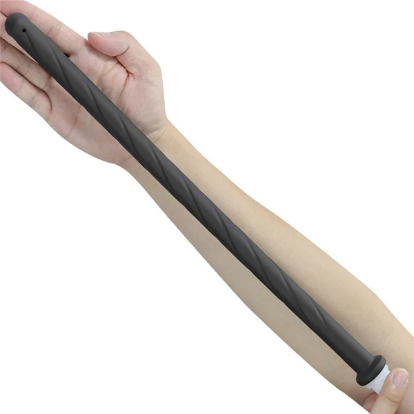 A hand is holding a black handheld bidet sprayer with a silicone hose.