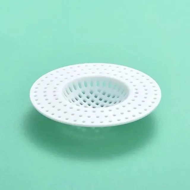 A white kitchen sink drain strainer and hair catcher with a perforated mesh design.