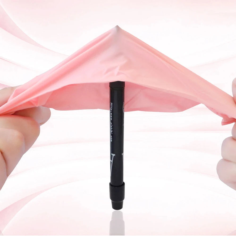 A hand holds up a pink durable nitrile cleaning glove, showing its folded shape.