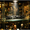 A black willow stick night light projector resting on a glass shelf among collectible figures.