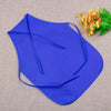 A royal blue non-woven craft apron is displayed on a beige fabric next to some yellow and green flowers.