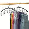 Curved metal hangers with ten clips used to organize clothing on a wooden rod.