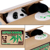Ein schwarz-weißes Panda-Plüschtier in einer Pappschachtel neben einem Etikett für einen Bambus-Pinguin-Sparschwein.