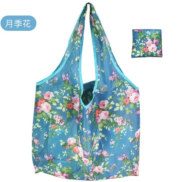 Helles blaues Blumen- wiederverwendbares Einkaufstasche mit rosa und grünen Blumen.