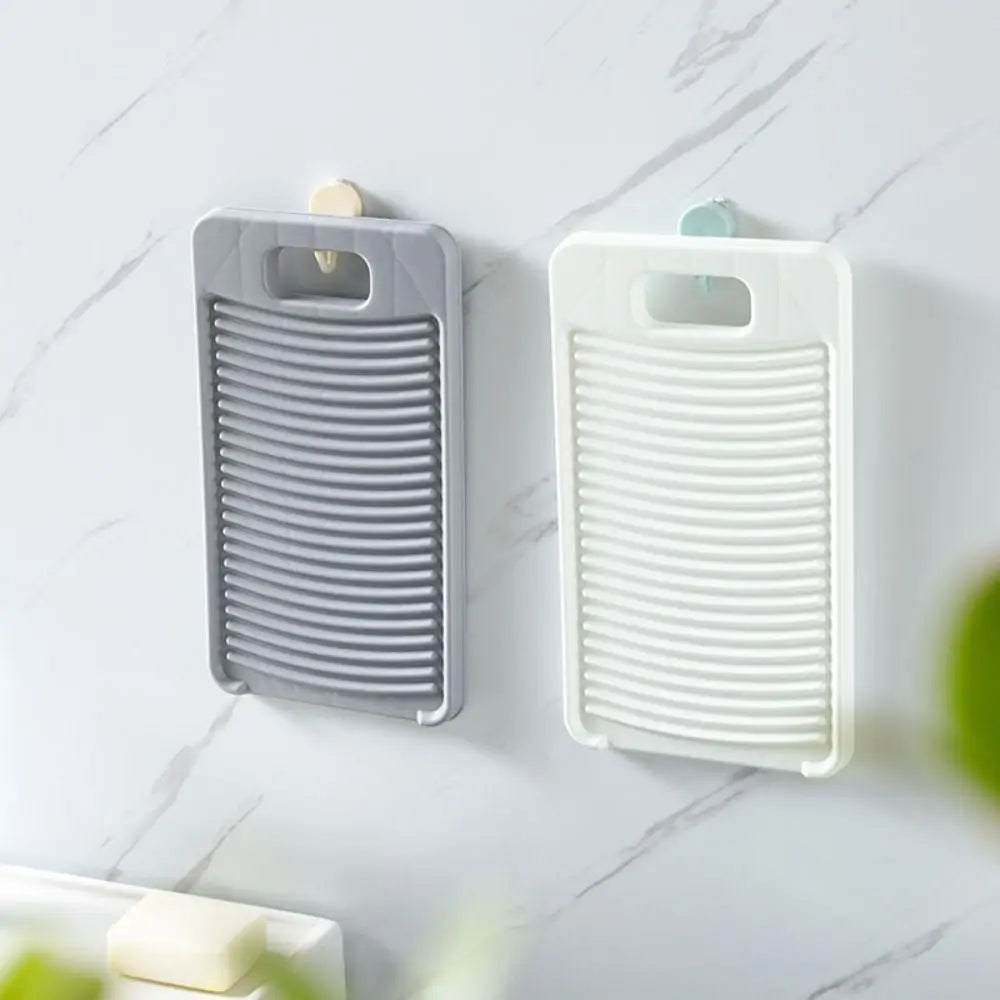 A gray and white durable fabric washing board hanging on a marble surface.