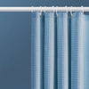 Light blue waterproof shower curtain hanging on a white rod