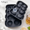 A black silicone sphere ice mold tray holding various spherical ice shapes for cocktails and whiskey