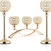 A set of gold crystal tealight candlesticks with decorative glass heads and a curved stand.