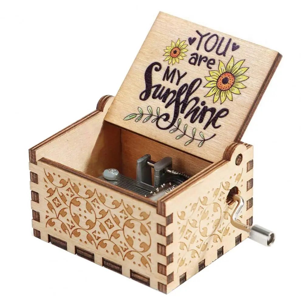 A small wooden music box with a lid featuring the text You are my sunshine and an engraved design.