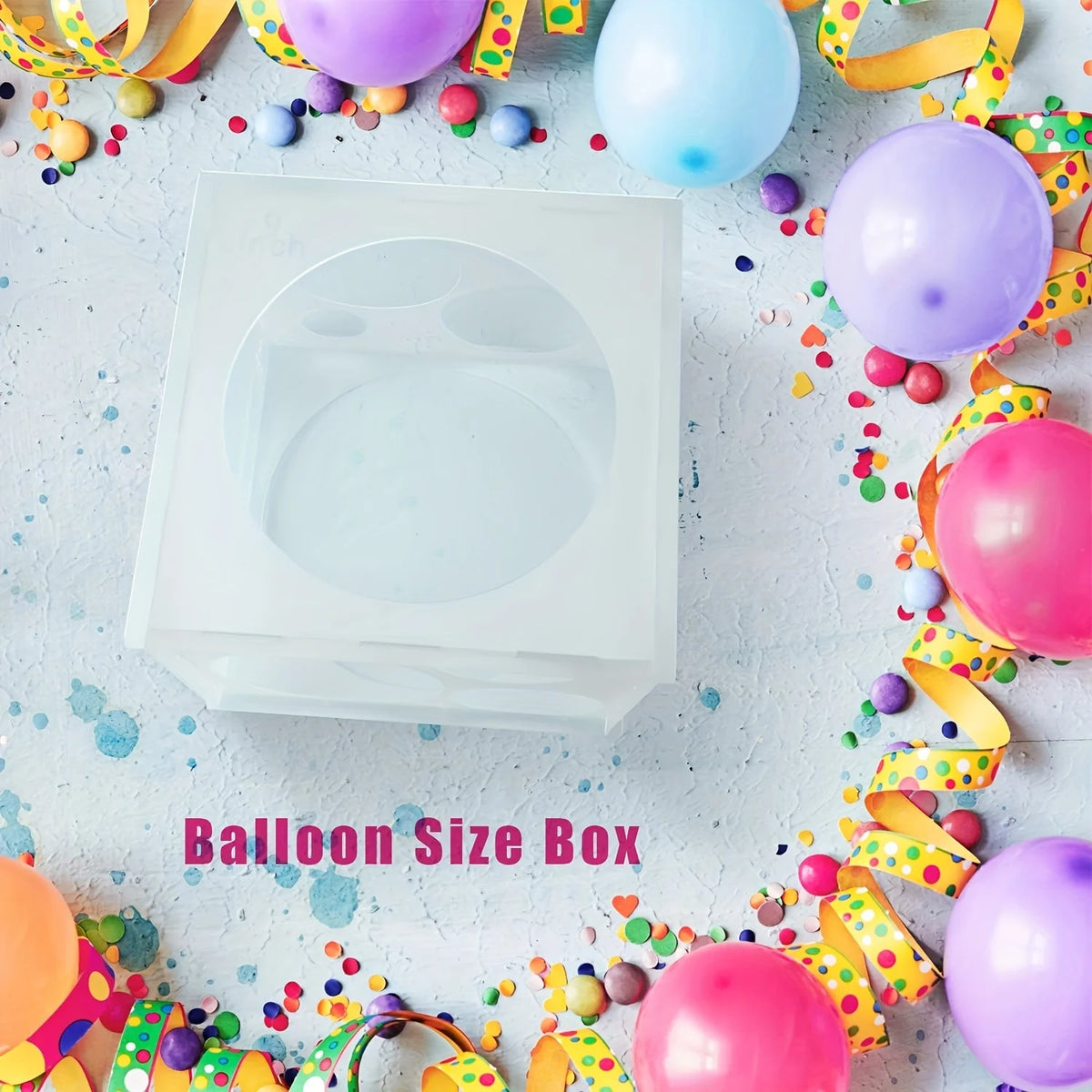 A white balloon size box with various colored balloons and confetti scattered around it.