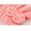 A close-up of a pink microfiber hair drying cap and towel with a textured, looped design.