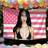 A woman wearing a black top posing in front of a pink and white American flag banner with stars.