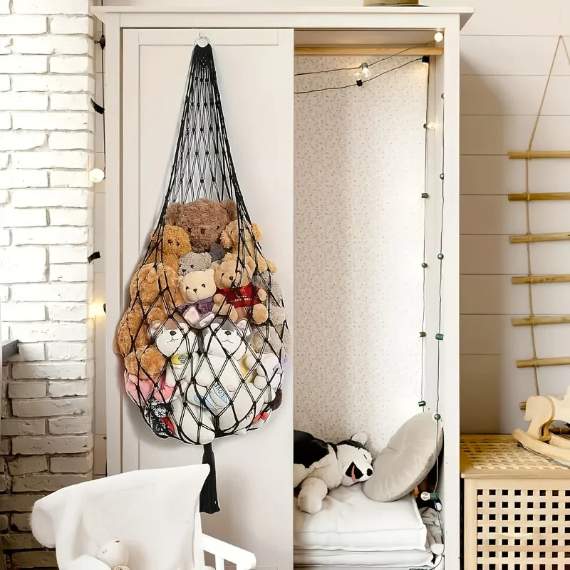 A white cabinet with a door open displaying a macrame hammock filled with various stuffed animals.