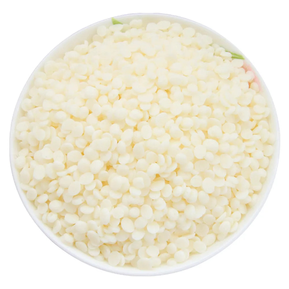 Un tazón lleno de pellets naturales de cera de soja blanca para hacer velas.