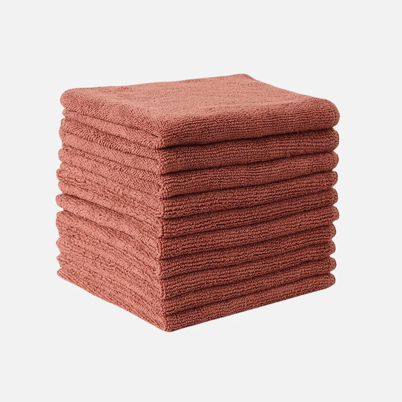 A stack of thick, rose-colored microfiber cleaning cloths for glass and surfaces.