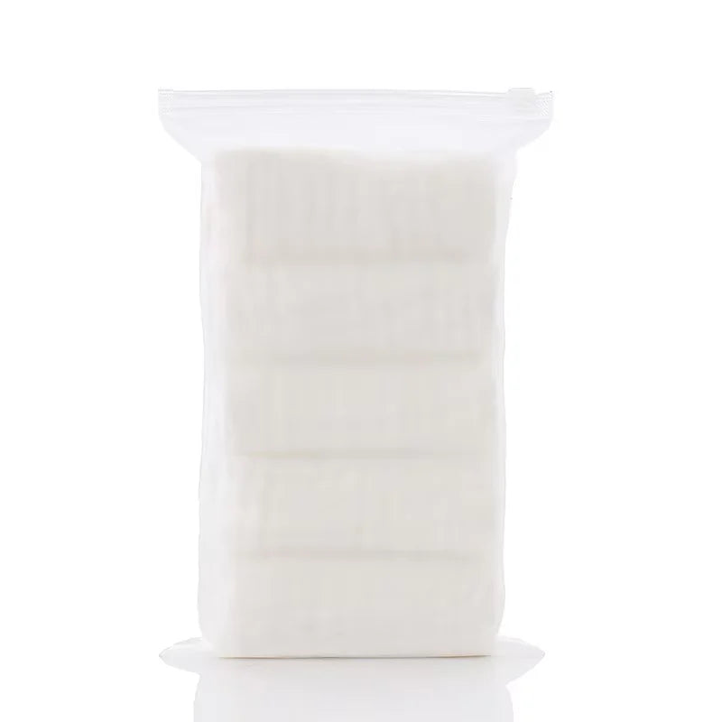 Un recipiente de plástico transparente lleno de un paquete de 5 toallitas orgánicas de algodón para bebé y cara.