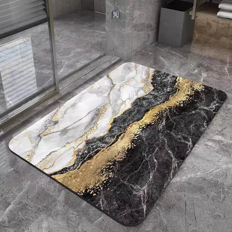 A rectangular bath mat with a marbled pattern featuring white, black, and gold accents on a gray floor.