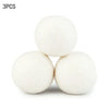 Three white reusable wool dryer balls stacked together