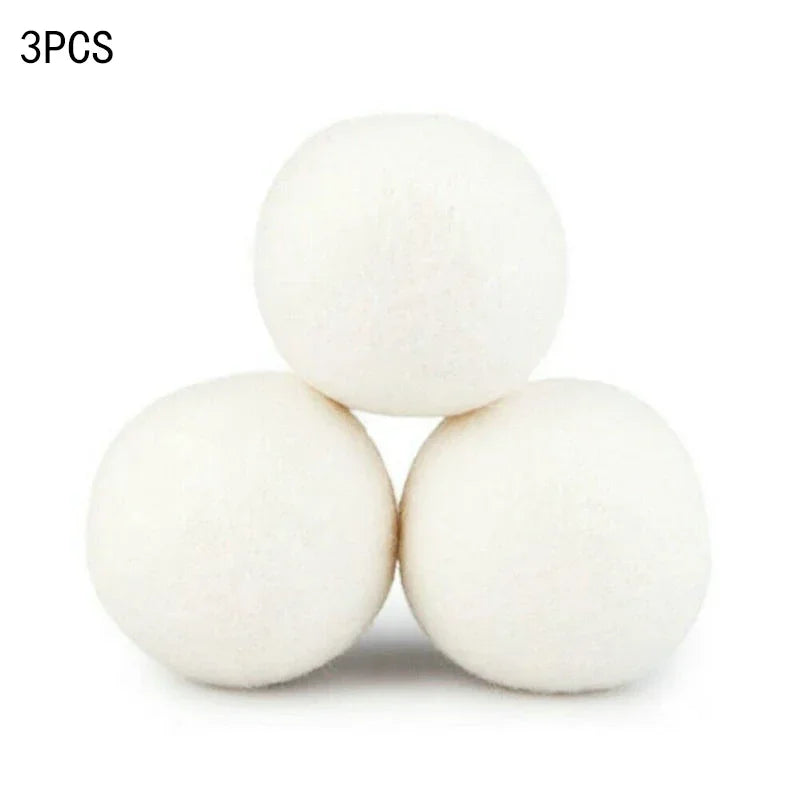 Three white reusable wool dryer balls stacked together