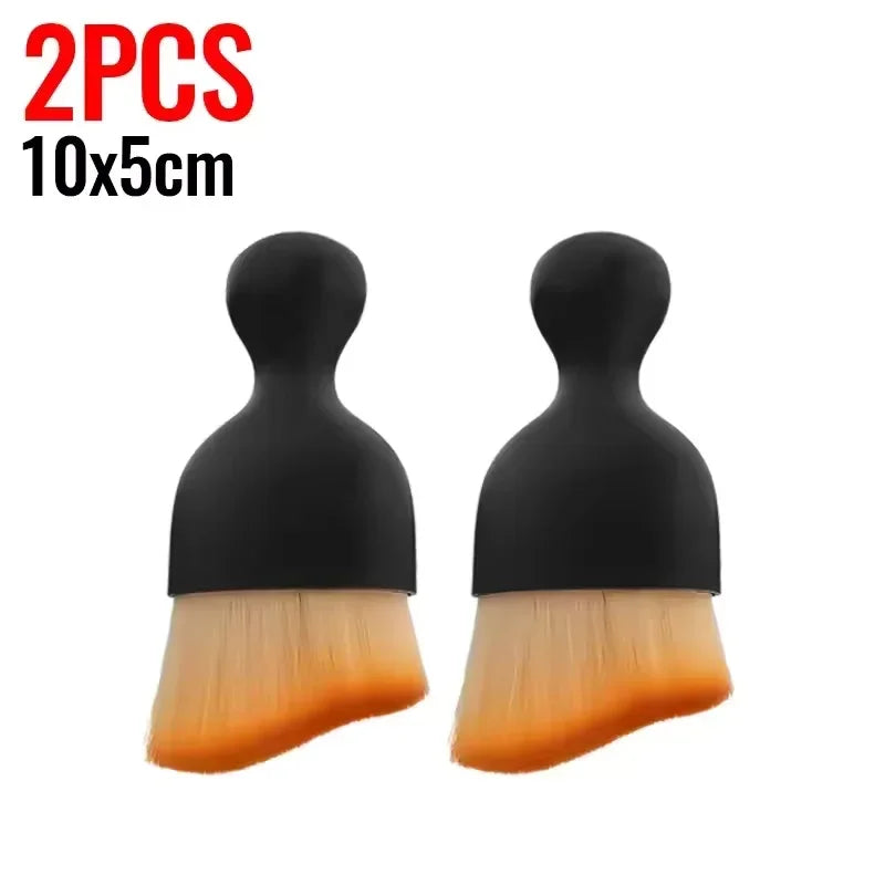 A pair of black multi-surface cleaning brushes with light yellow bristles.