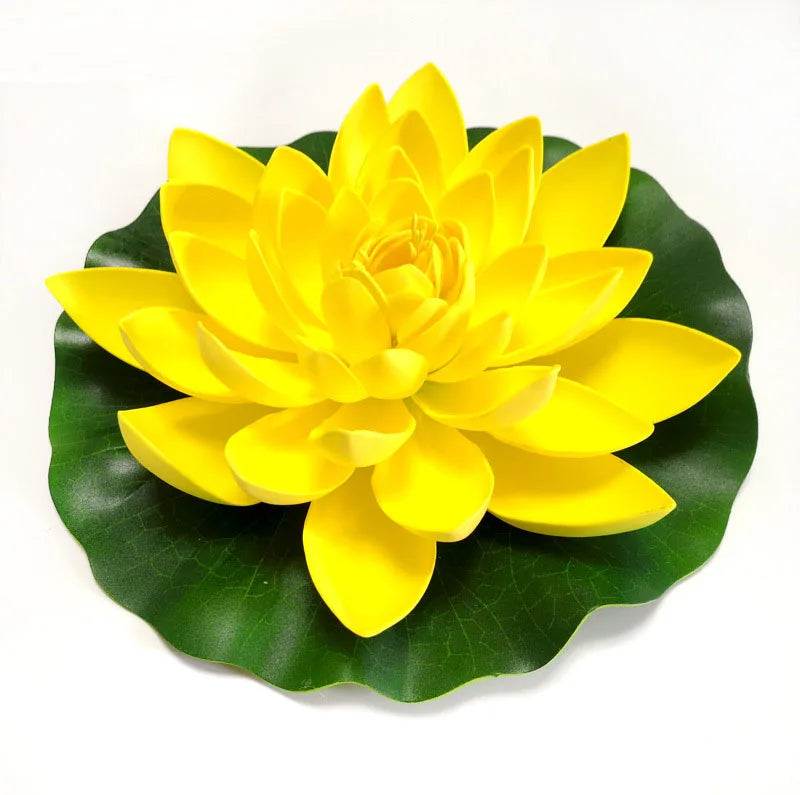 A bright yellow artificial lotus flower blooming on a green leaf.