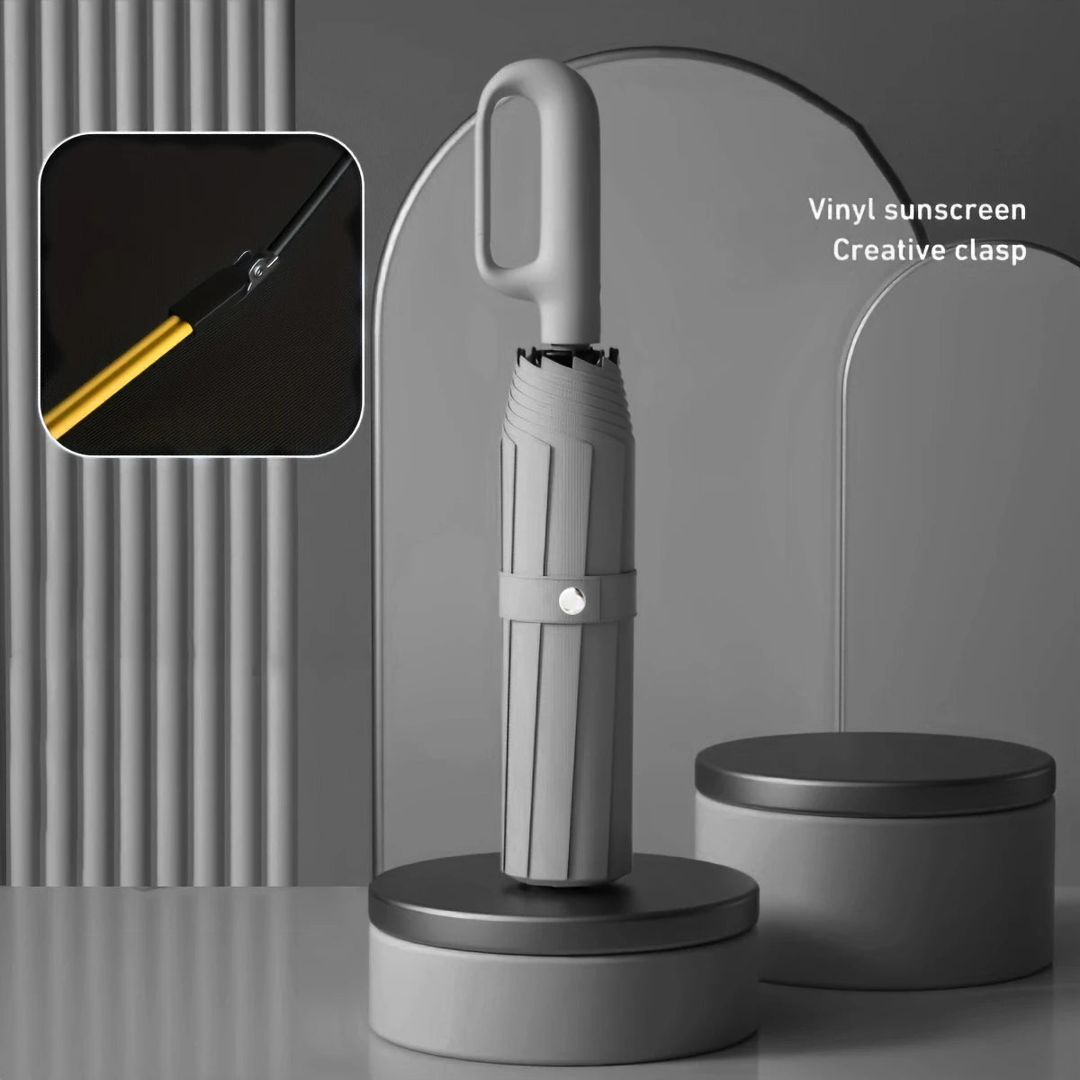 A silver vinyl sunscreen creative clasp on a folding umbrella handle displayed against a gray background.