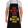 A man wearing a black apron with text that reads Kiss the Cook and Bring him a Beer