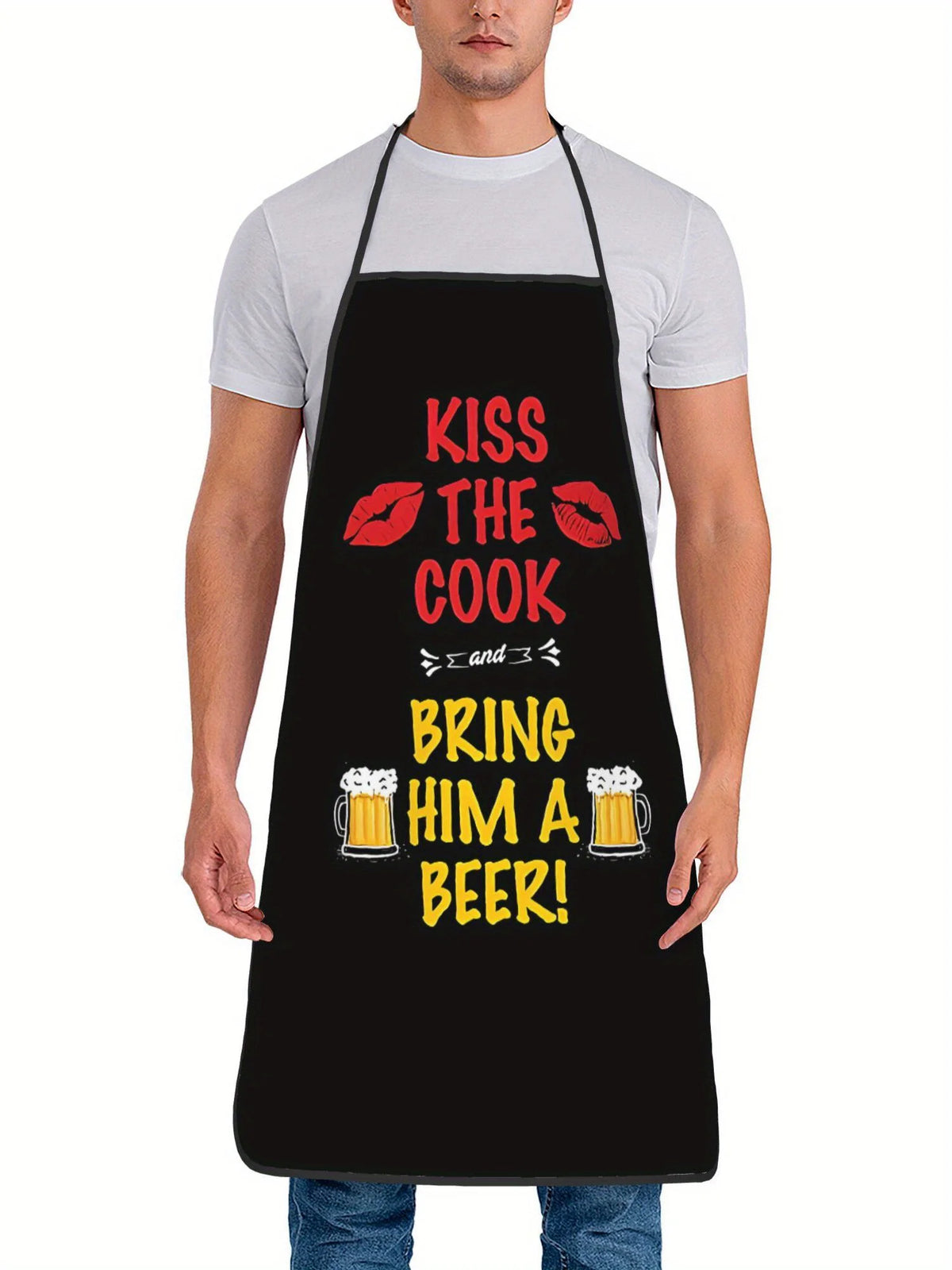 A man wearing a black apron with text that reads Kiss the Cook and Bring him a Beer