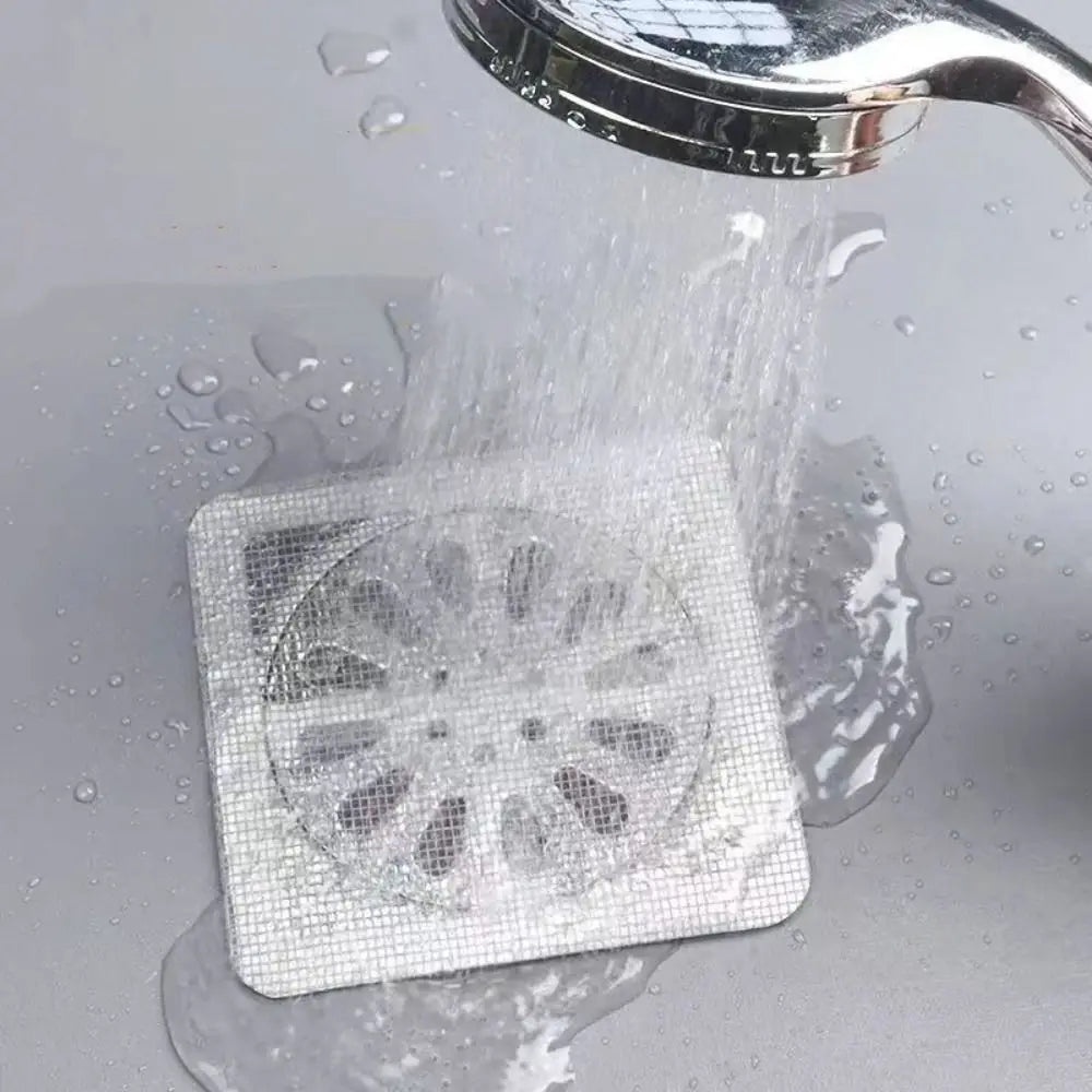 Eine weiße Einweg-Abflussfilter-Sticker wird unter fließendem Wasser abgespült.