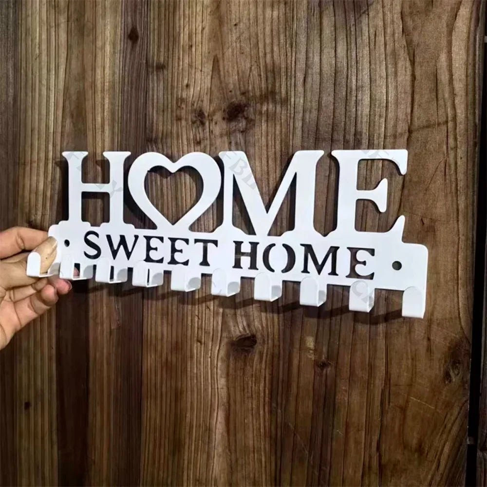 White wooden wall hook key holder with the words HOME and SWEET HOME carved into the wood