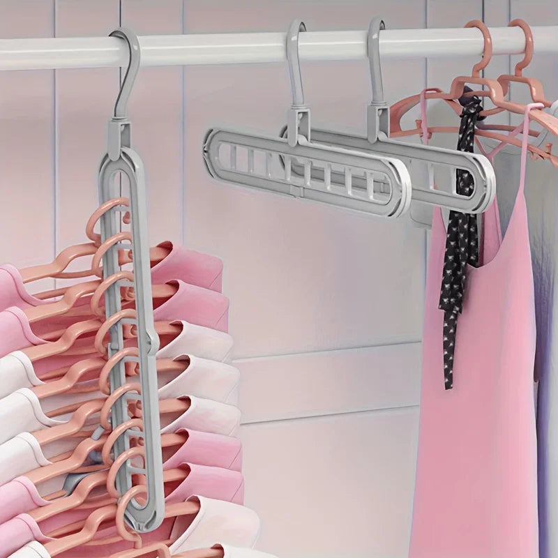 A set of three light gray foldable plastic hangers hanging on a clothes rack.