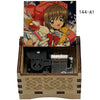 A wooden box containing a musical tone box and an anime-style illustration of a girl with a yellow bear.