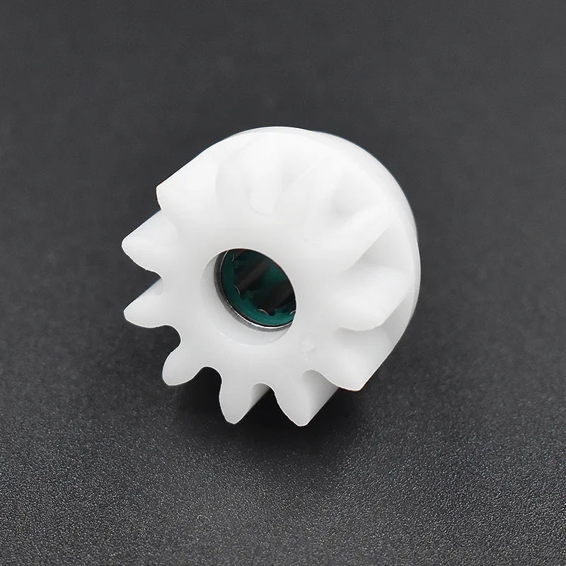 A white replacement gear with a dark green center is shown against a dark background.
