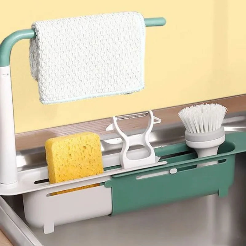 A white dish rack organizer with a hanging towel and a slotted tray for dishes is shown in a kitchen sink.