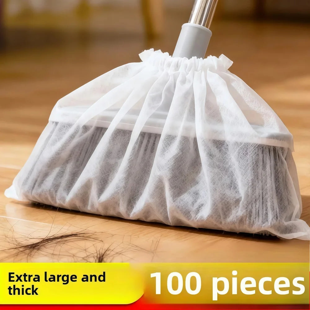 A white disposable broom cover made of sheer mesh fabric is shown on a wooden floor.