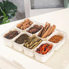 A clear organizer tray holds eight compartments filled with various dried spices and herbs for cooking.