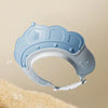 A light blue adjustable baby bath shampoo shield cap is shown against a beige background.