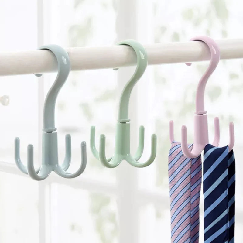 Three pastel colored closet organizer hooks hanging on a wooden rod.