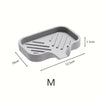 A gray silicone sink mat and organizer with ridges for drainage and organization.