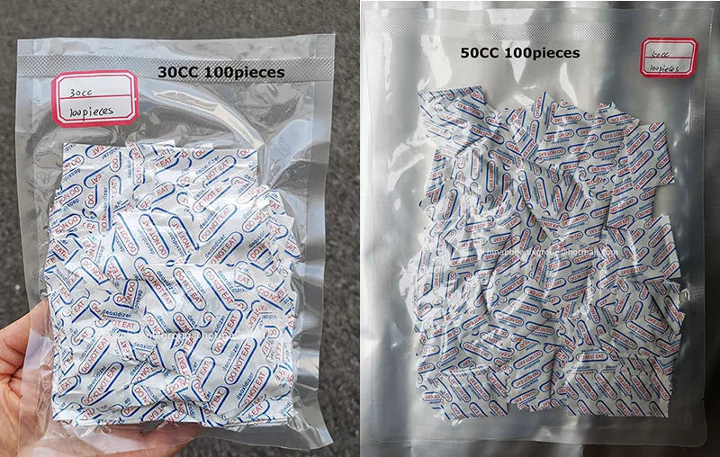 A hand holds a clear plastic bag containing 100 food-grade oxygen absorbers for extended dry food storage.