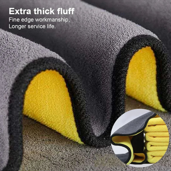 Close-up of a dark gray microfiber car wash towel with thick fluff and yellow lining, showing the fine edge workmanship.
