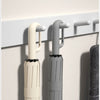 Two automatic folding umbrellas, one cream and one gray, are mounted on a wall rack.