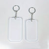 Two clear acrylic keychains with silver split rings and blank white rectangular tags.
