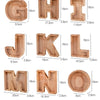 Ensemble de lettres alphabétiques en bois G, H, J, K, L, M et N, utilisées comme tirelire pour économiser.