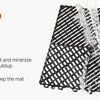A hand is rinsing a black interlocking drainage mat with water.